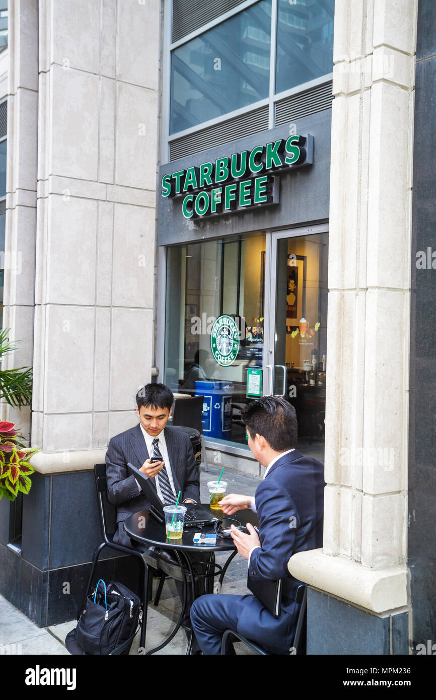 Toronto Canada,Yorkville,Bloor Street,Asian man men male adult adultsal attire,suit,tie,cafe,Starbucks Coffee,barista,company,logo,sign,wireless,check Stock Photo