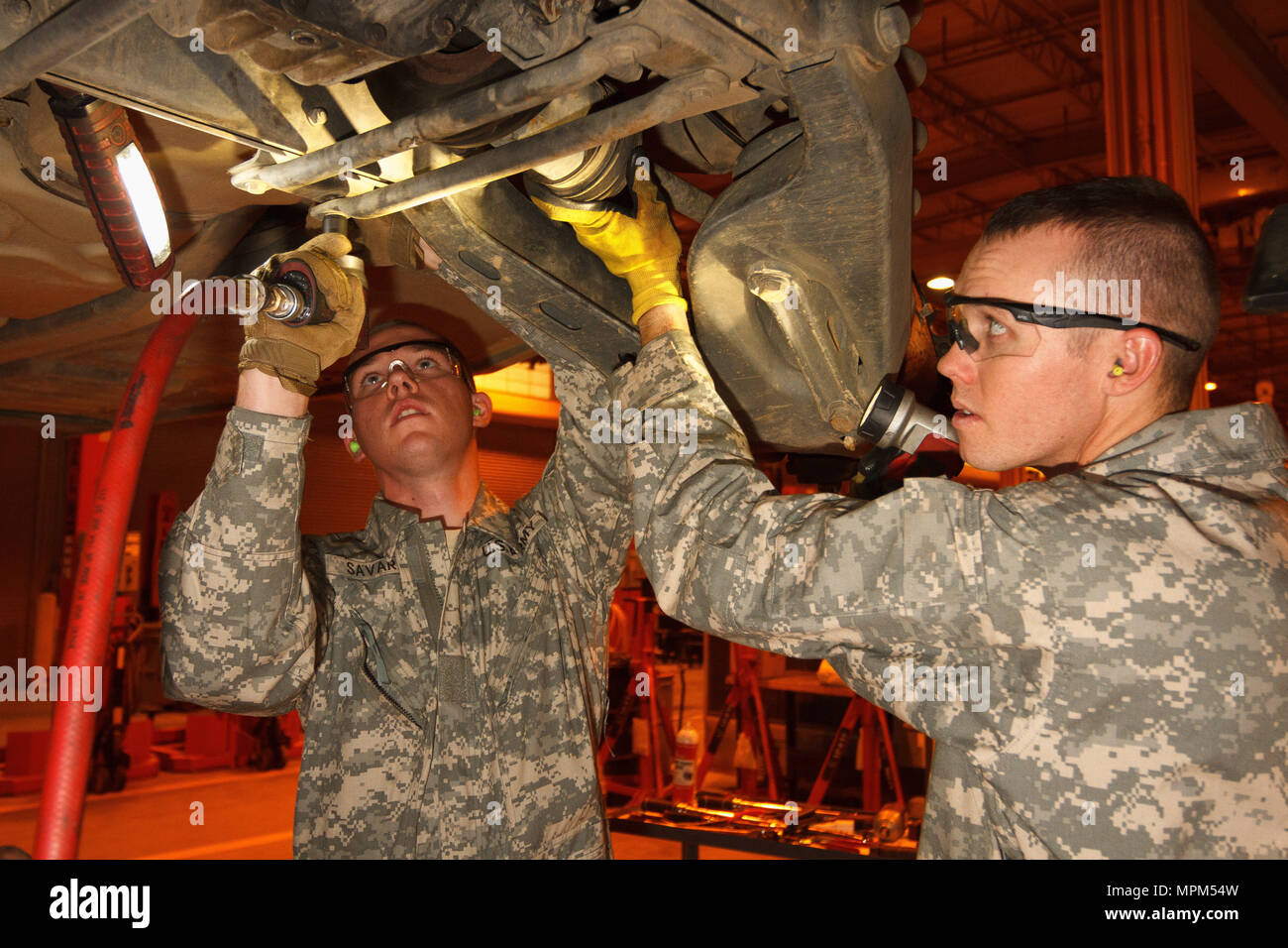 Arizona Army National Guard Pvt. Adam J. Savard and Pvt. Dakota S. Bohl work to remove the half-shaft on an M1097A2 Humvee during an inspection service March 14, 2017 at the TACOM Fleet Management Expansion, Tactical Vehicle Division, on Fort Benning, Georgia. The Soldiers, who are wheeled vehicle mechanics with the 3666th Support Maintenance Company, are at Fort Benning conducting their 15-day annual training. (Arizona Army National Guard photo by Staff Sgt. Brian A. Barbour) Stock Photo