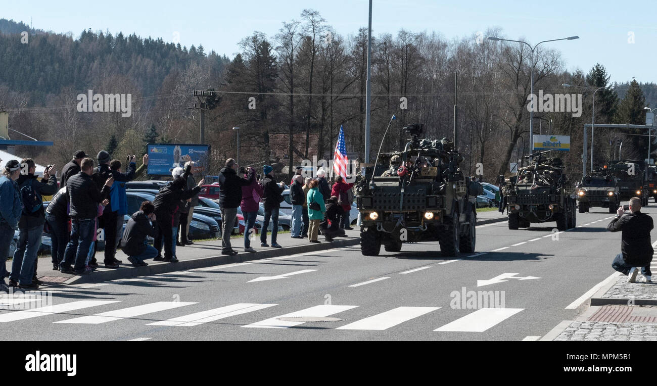 Polish citizens greet the Soldiers of Battle Group Poland as the convoy of tactical vehicles crosses the border from the Czech Republic into Poland March 26, 2017. The contingency of U.S., United Kingdom and Romanian Soldiers convoyed to Orzysz, Poland where they will integrate with the Polish 15th Mechanized Brigade, 16th Infantry Division. The U.S. Army 2nd Squadron, 2nd Cavalry Regiment and other Troop Contributing Nations making up Battle Group Poland will deploy to Poland as part of NATO's Enhanced Forward Presence to serve as a deterrence force. The unique formation is designed to demons Stock Photo