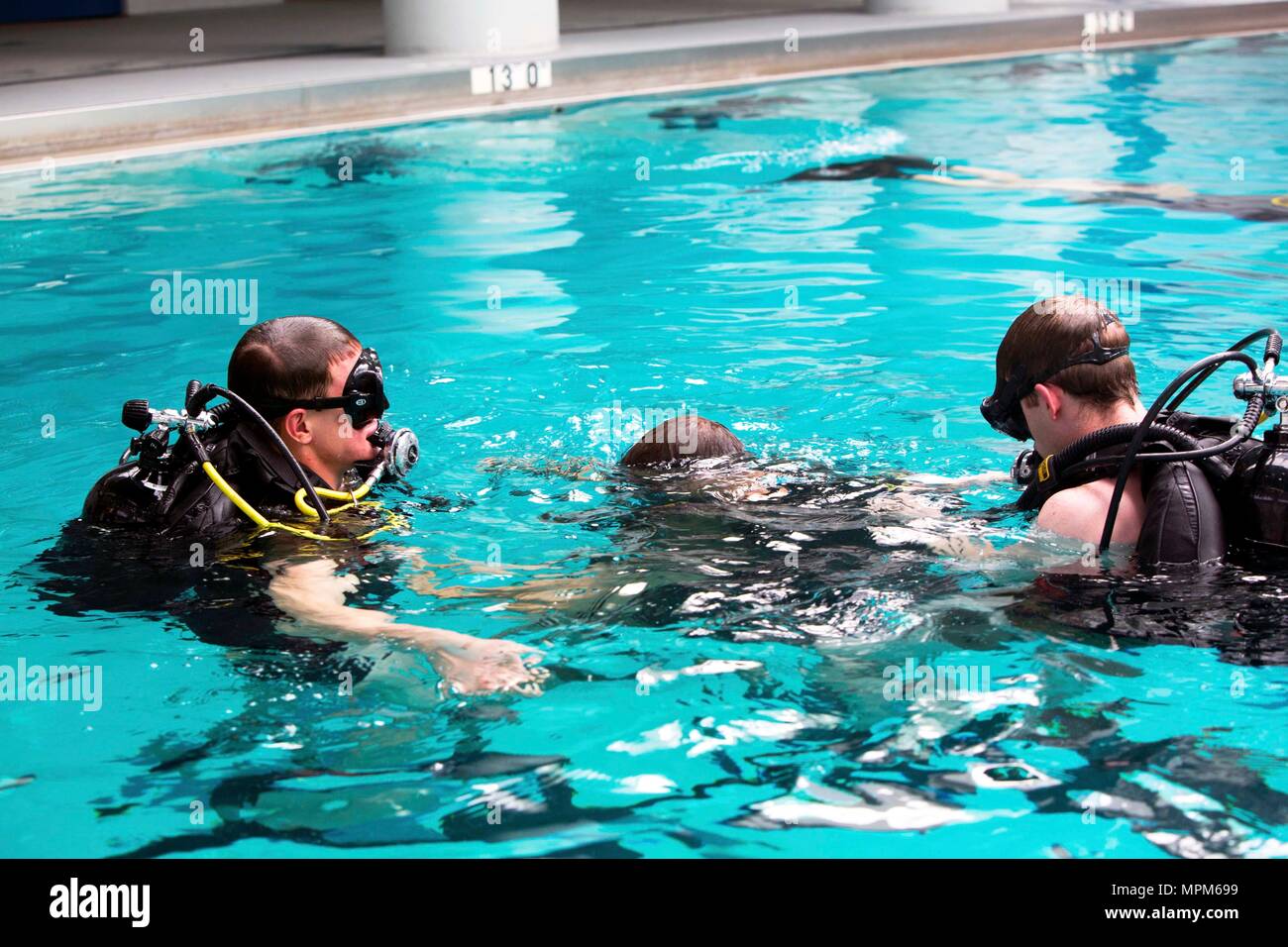 Marines conduct dive training in small groups to ensure safety in the pool during a battalion training event at Camp Lejeune, N.C., March 23, 2017. The Marines conducted training with the self-contained underwater breathing apparatus to maintain proficiency and confidence in their combat diving skills. The Marines are with 2nd Reconnaissance Battalion, 2nd Marine Division. (U.S. Marine Corps photo by Sgt. Clemente C. Garcia) Stock Photo
