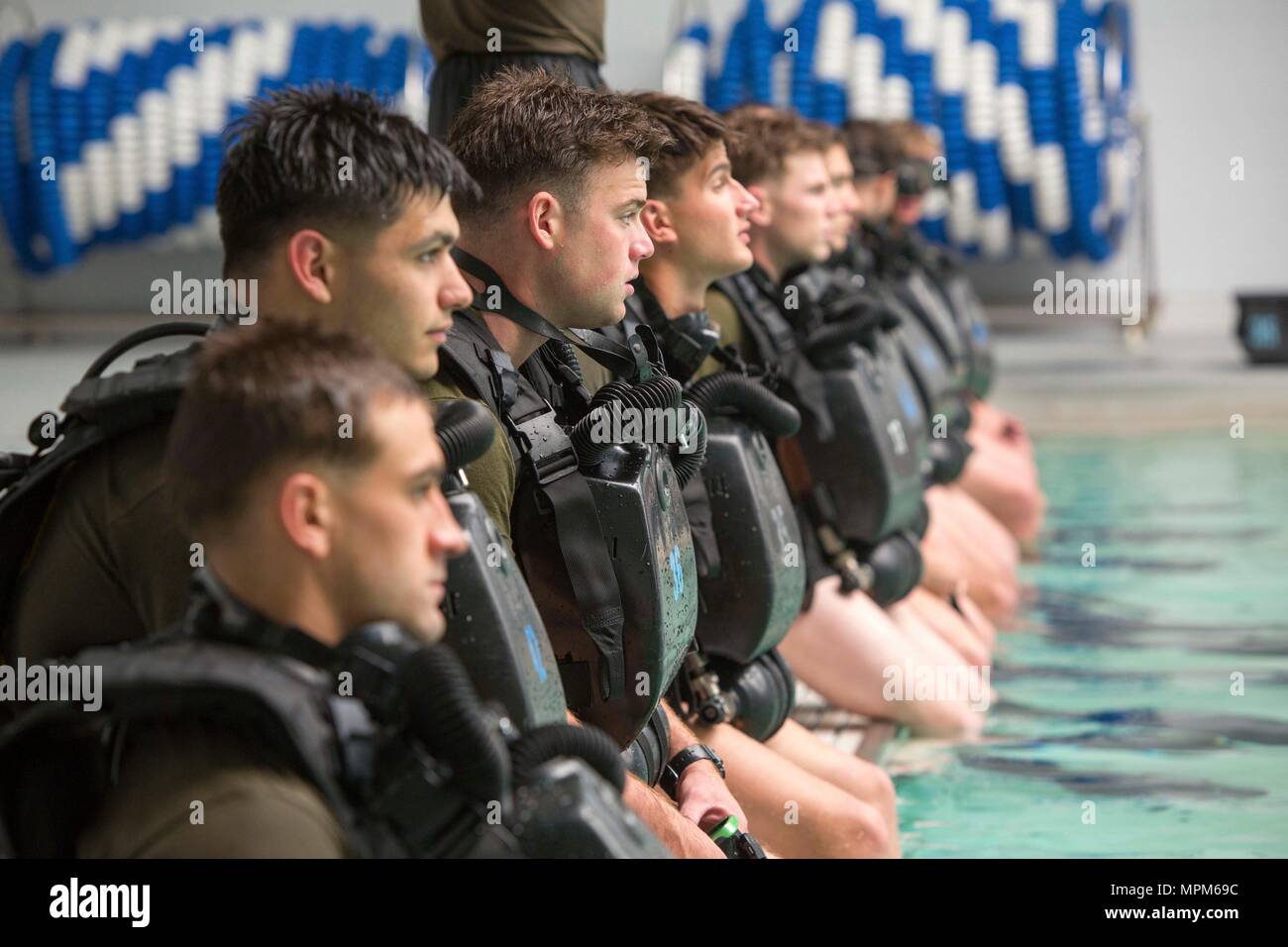 Marines await the command to enter the pool during a battalion training event at Camp Lejeune, N.C., March 23, 2017. The Marines conducted training with the MK-25 underwater breathing apparatus to maintain proficiency and confidence in their combat diving skills. The Marines are with 2nd Reconnaissance Battalion, 2nd Marine Division. (U.S. Marine Corps photo by Sgt. Clemente C. Garcia) Stock Photo