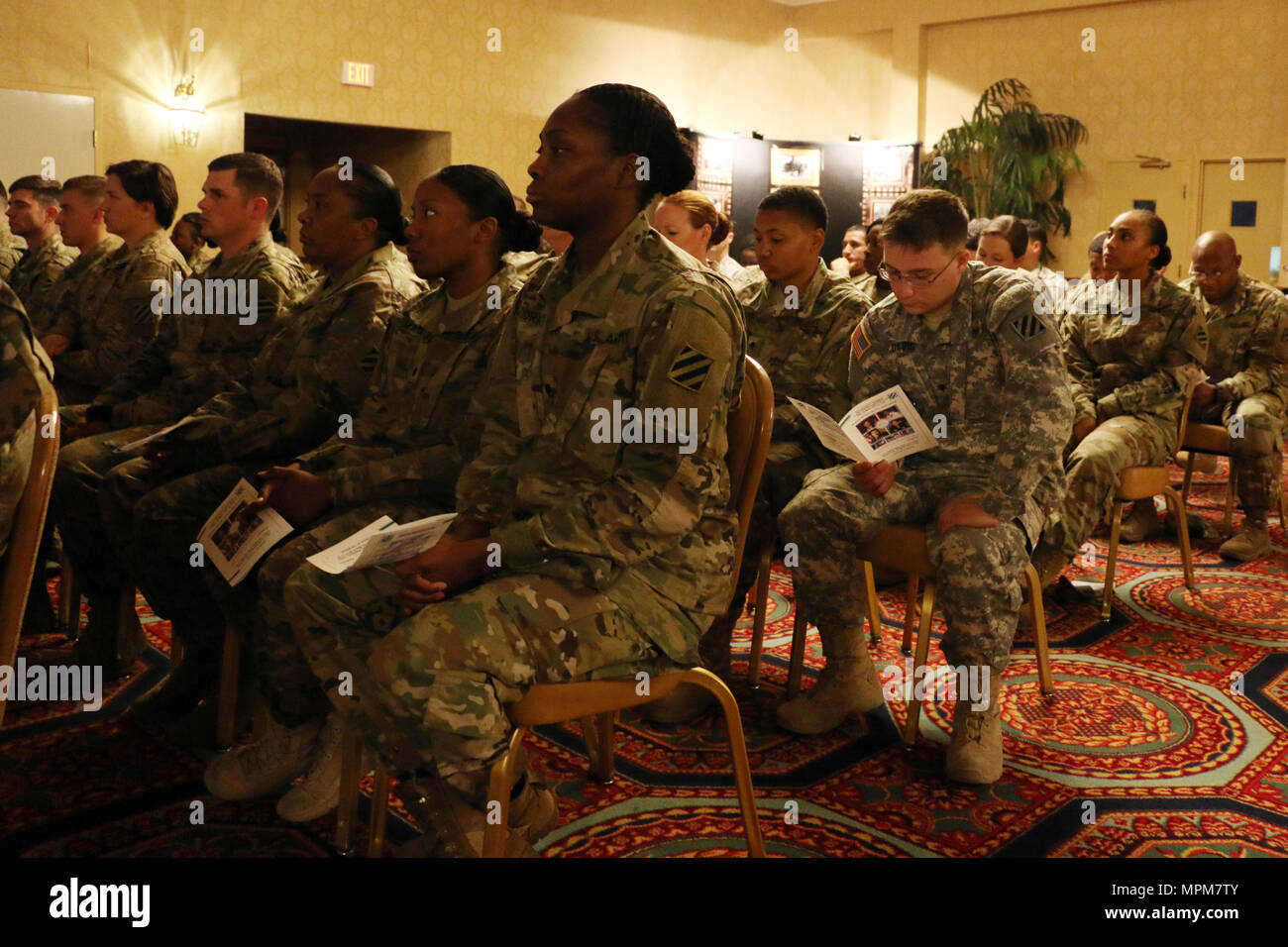 Soldiers of 3rd Infantry Division listen to the guest speaker at a Women’s History Month observance March 22, 2017 at Fort Stewart, Ga. This year’s theme was “Honoring trailblazing women.” (U.S. Army photo by Staff Sgt. Candace Mundt/Released) Stock Photo