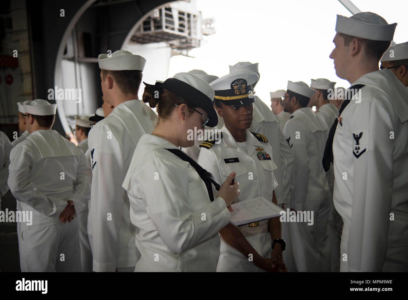 170328-N-LA456-008    NORFOLK, Va. (March 28, 2017) Lt.j.g. Camille Ross, center, from St. Leonard, Md., and Machinist's Mate (Nuclear) 1st Class Vallori Barber, from Miamisburg, Ohio, conduct a dress whites inspection in the hangar bay of the aircraft carrier USS Dwight D. Eisenhower (CVN 69) (Ike). Ike is currently pier side during the sustainment phase of the Optimized Fleet Response Plan (OFRP). (U.S. Navy photo by Mass Communication Specialist Seaman K. A. DaCosta) Stock Photo