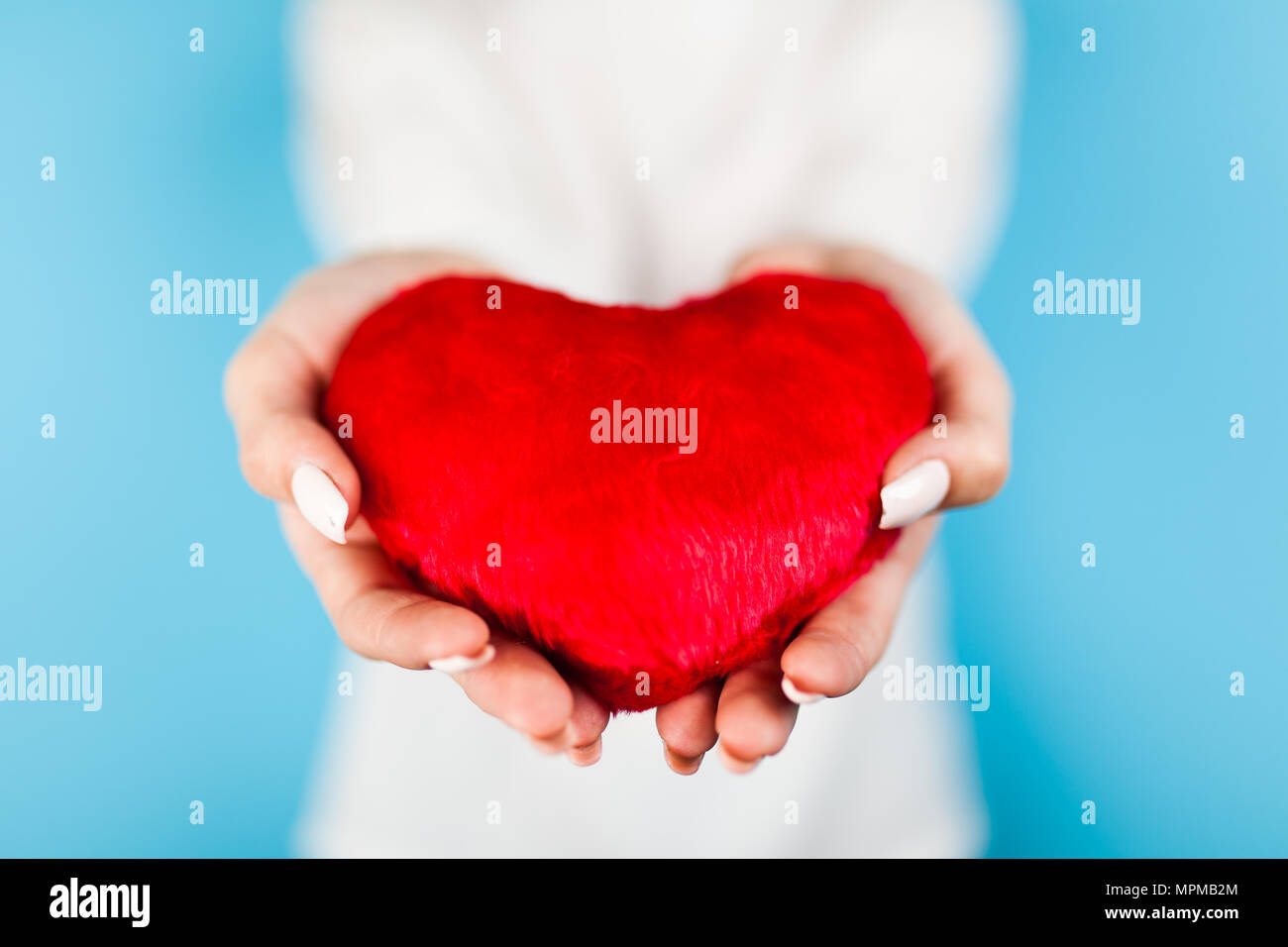 Female hands holding a red heart Stock Photo - Alamy