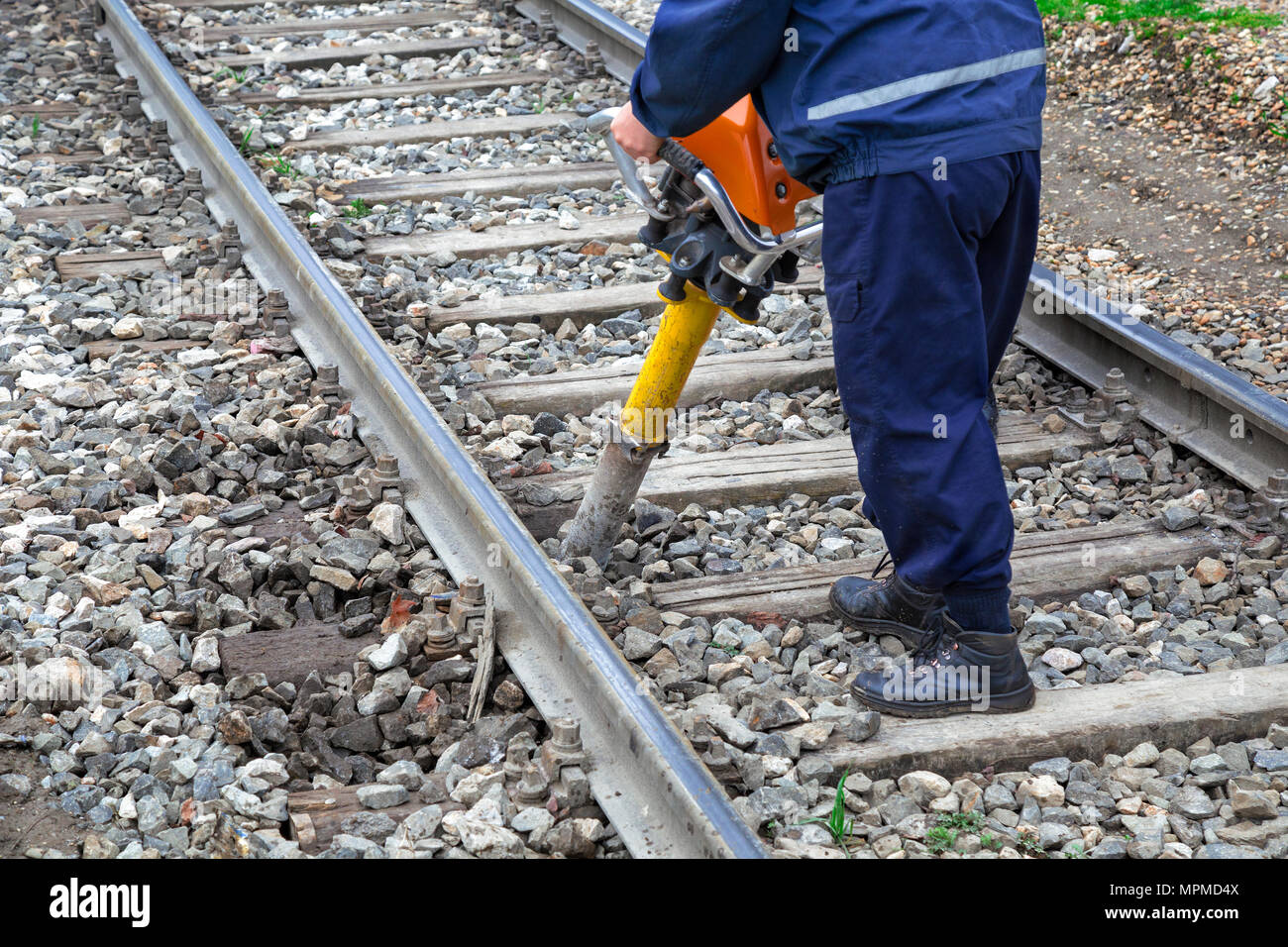 Track laborer perform maintenance of way on railroad tracks using