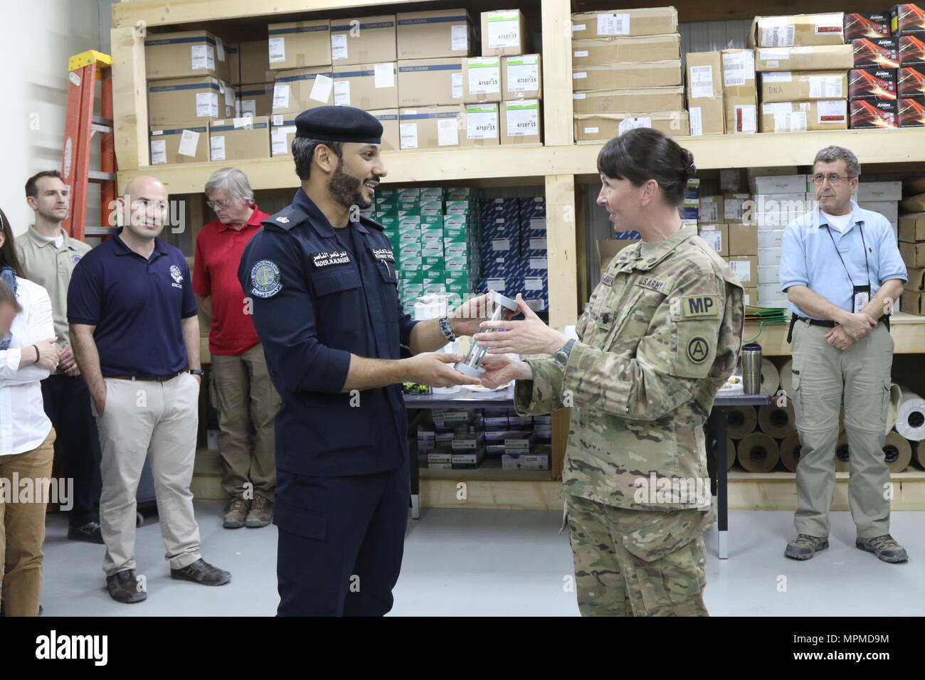 U.S. Army Lt. Col. Ann Sampson (right), the laboratory officer in charge of the Forensic Exploitation Team- Arifjan, presents a plaque to Maj. Bader Alnser, a Kuwait police officer, as a thank you for visiting the facility, March 23, at Camp Arifjan, Kuwait. The visit strengthens the partnership between the agencies through sharing techniques and demonstrating some of the capabilities the lab has. (U.S. Army photo by Sgt. Bethany Huff, USARCENT Public Affairs) Stock Photo