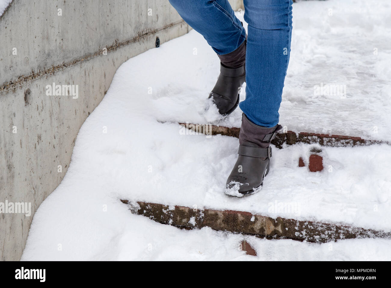 Woman steps in snow winter walking down the stairs Stock Photo