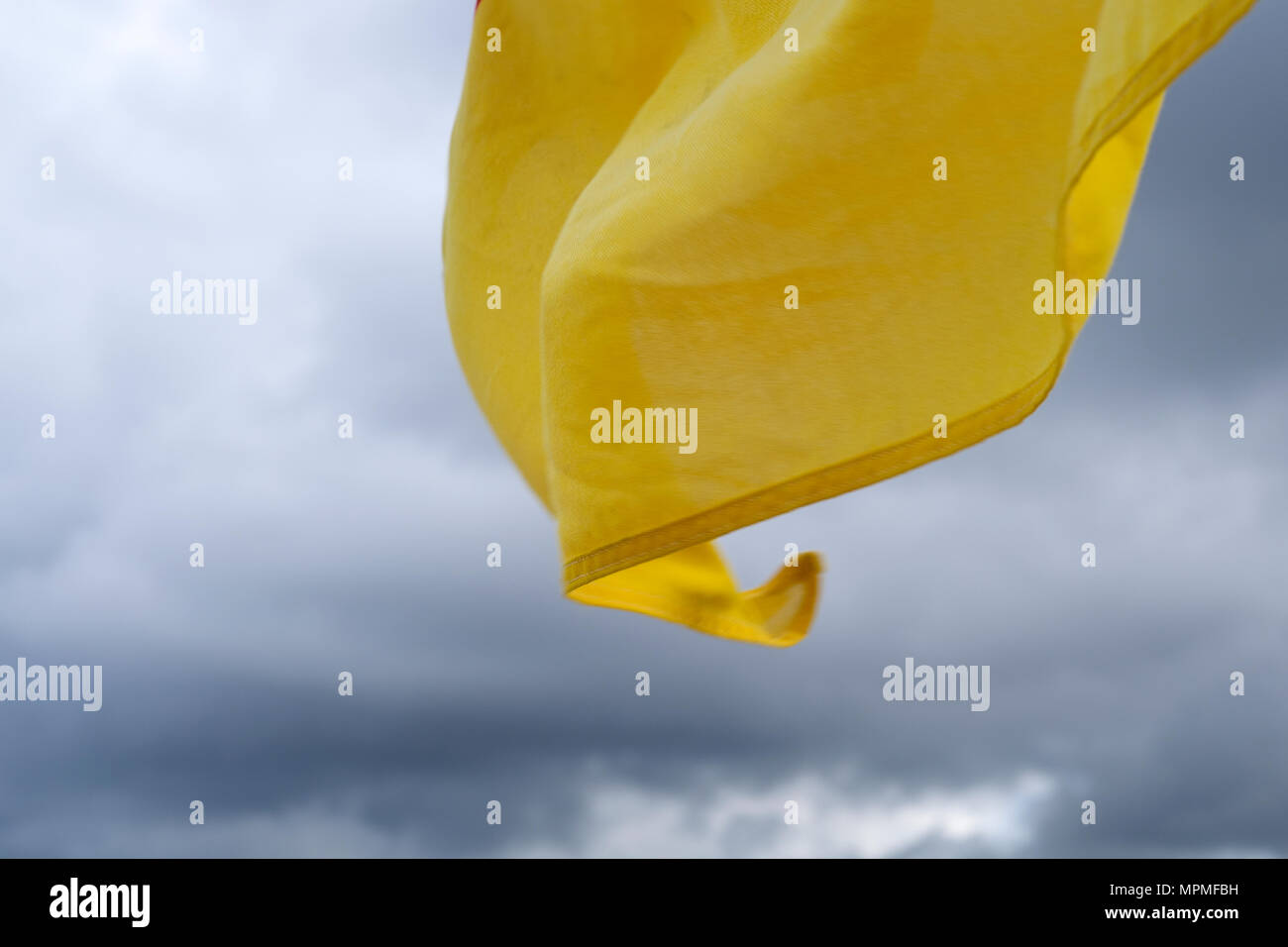 Red & Yellow RNLI Safety Flags on the beach with cloudy blue skies