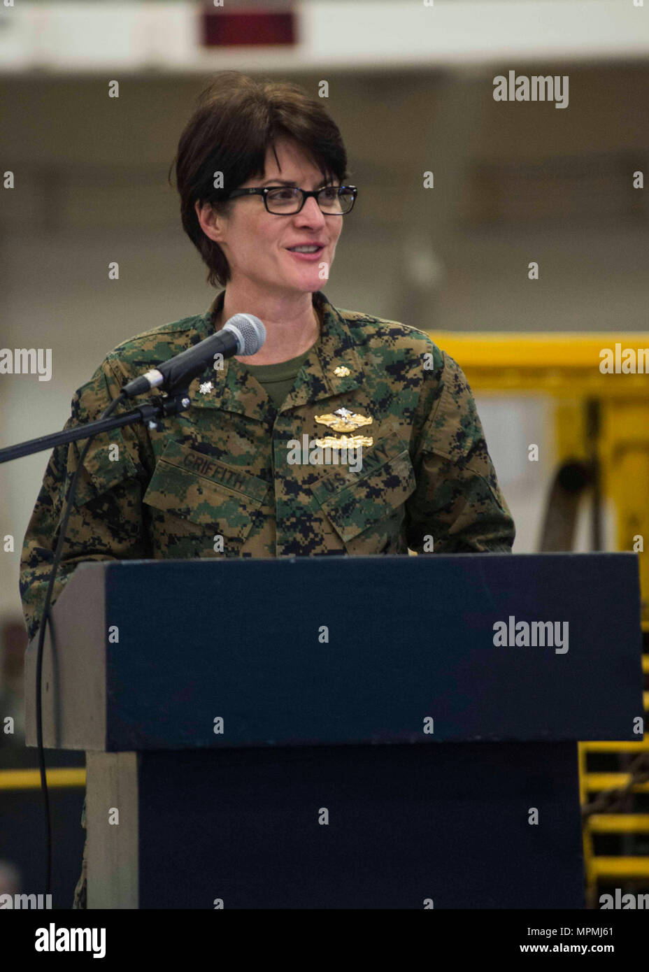 INDIAN OCEAN (March 30, 2017) Cmdr. Erin Griffith, 11th Marine  Expeditionary Unit Surgeon, delivers comments at the women's history month  ceremony in the hangar bay of the amphibious assault ship USS Makin