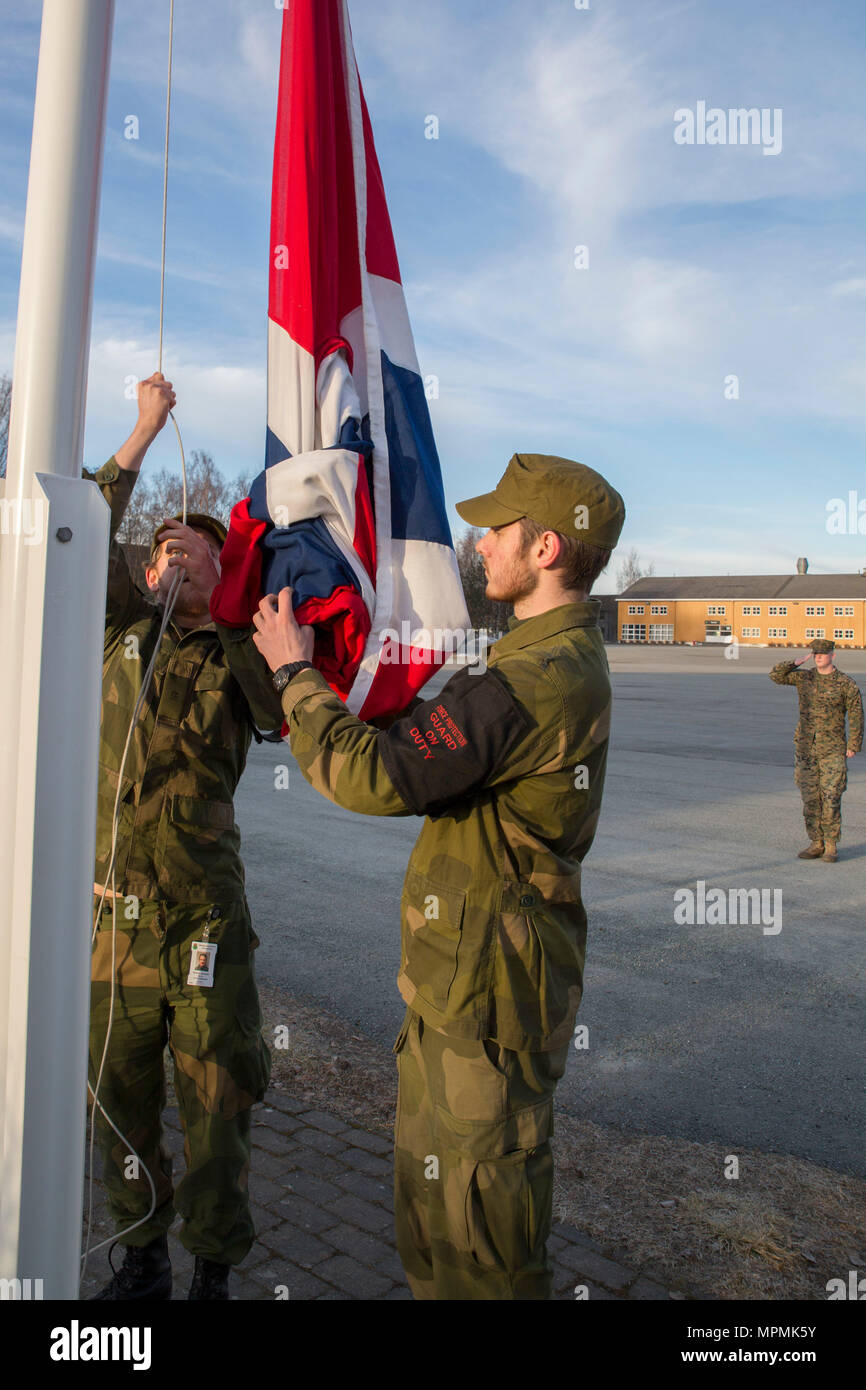 Soldiers with Home Guard 12 fly the Norwegian flag at Vaernes Garnison, March 30, 2017. Marine Rotational Force Europe 17.1 (MRF-E) upholds traditions as Marines and sailors operate from Norway, galvanizing the Marine Corps’ long and close relationship with the Norwegian Armed Forces. (U.S. Marine Corps photo by Lance Cpl. Victoria Ross) Stock Photo