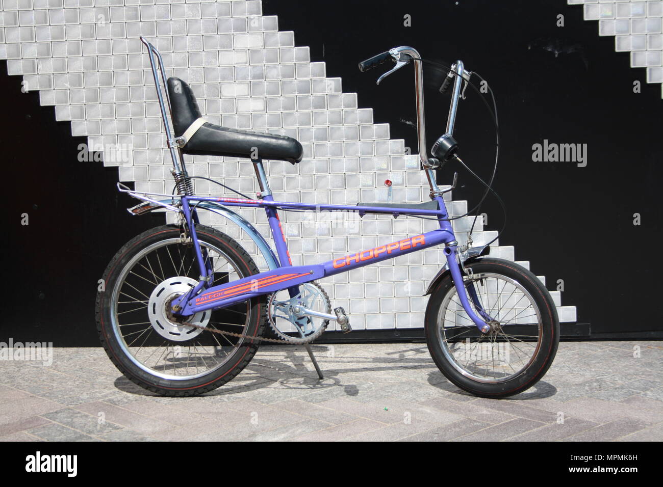 Classic Retro Rayleigh Chopper, back drop is the No. 700 Reflectors artwork featured in Cubitt Square, Kings Cross London Stock Photo