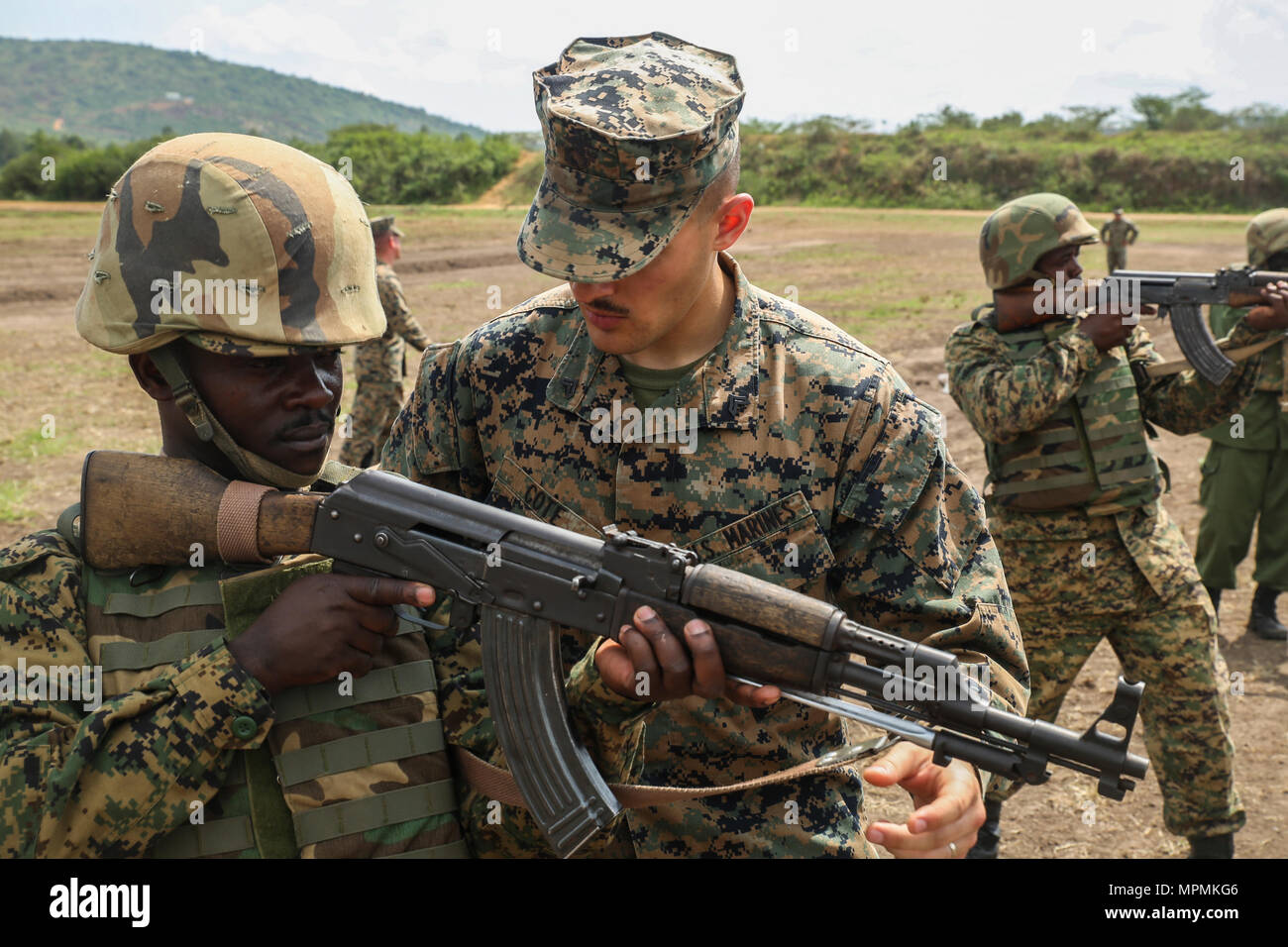 Cpl. Jordan R. Cote, a generator mechanic with Special Purpose Marine  Air-Ground Task Force – Crisis Response – Africa, gives advice about the  standing position to a soldier with the Uganda People's