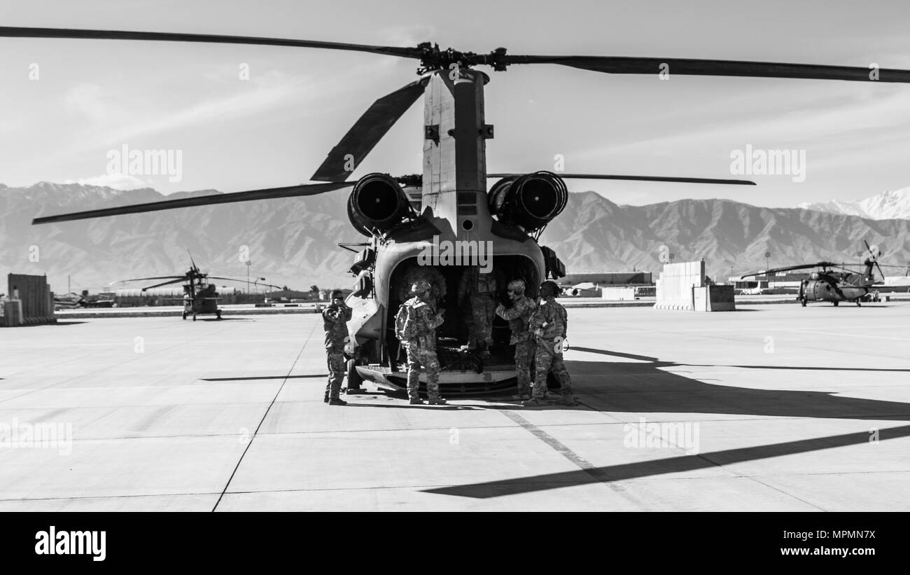 U.S. Army Soldiers assigned to 1st Squadron, 14th Cavalry Regiment, 1st Stryker Brigade Combat Team, 2nd Infantry Division load onto a CH-47 Chinook helicopter assigned to Task Force Flying Dragon, 16th Combat Aviation Brigade, 7th Infantry Division during training at Bagram Airfield, Afghanistan, April 1, 2017. The Cavalry troopers provide a ready response force for downed aircraft, and the training focused on preparing them to assume their mission in support of Operation Freedom’s Sentinel and Resolute Support Mission. Stock Photo