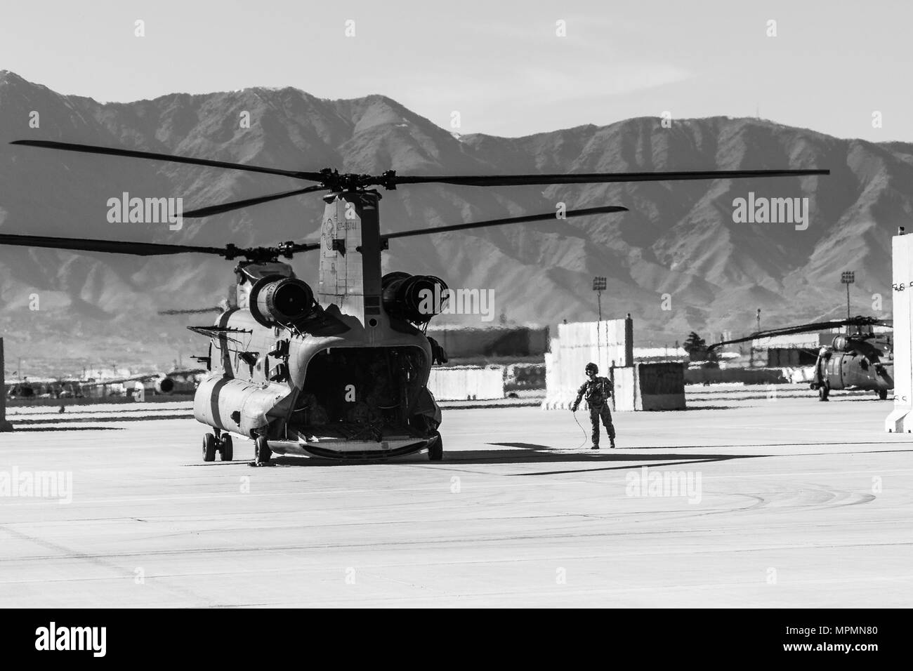 A U.S. Army CH-47 helicopter crew chief assigned to Task Force Flying Dragon, 16th Combat Aviation Brigade, 7th Infantry Division prepares for a flight carrying U.S. Army Soldiers assigned to 1st Squadron, 14th Cavalry Regiment, 1st Stryker Brigade Combat Team, 2nd Infantry Division during training at Bagram Airfield, Afghanistan, April 1, 2017. The Cavalry troopers provide a ready response force for downed aircraft, and the training focused on preparing them to assume their mission in support of Operation Freedom’s Sentinel and Resolute Support Mission. Stock Photo