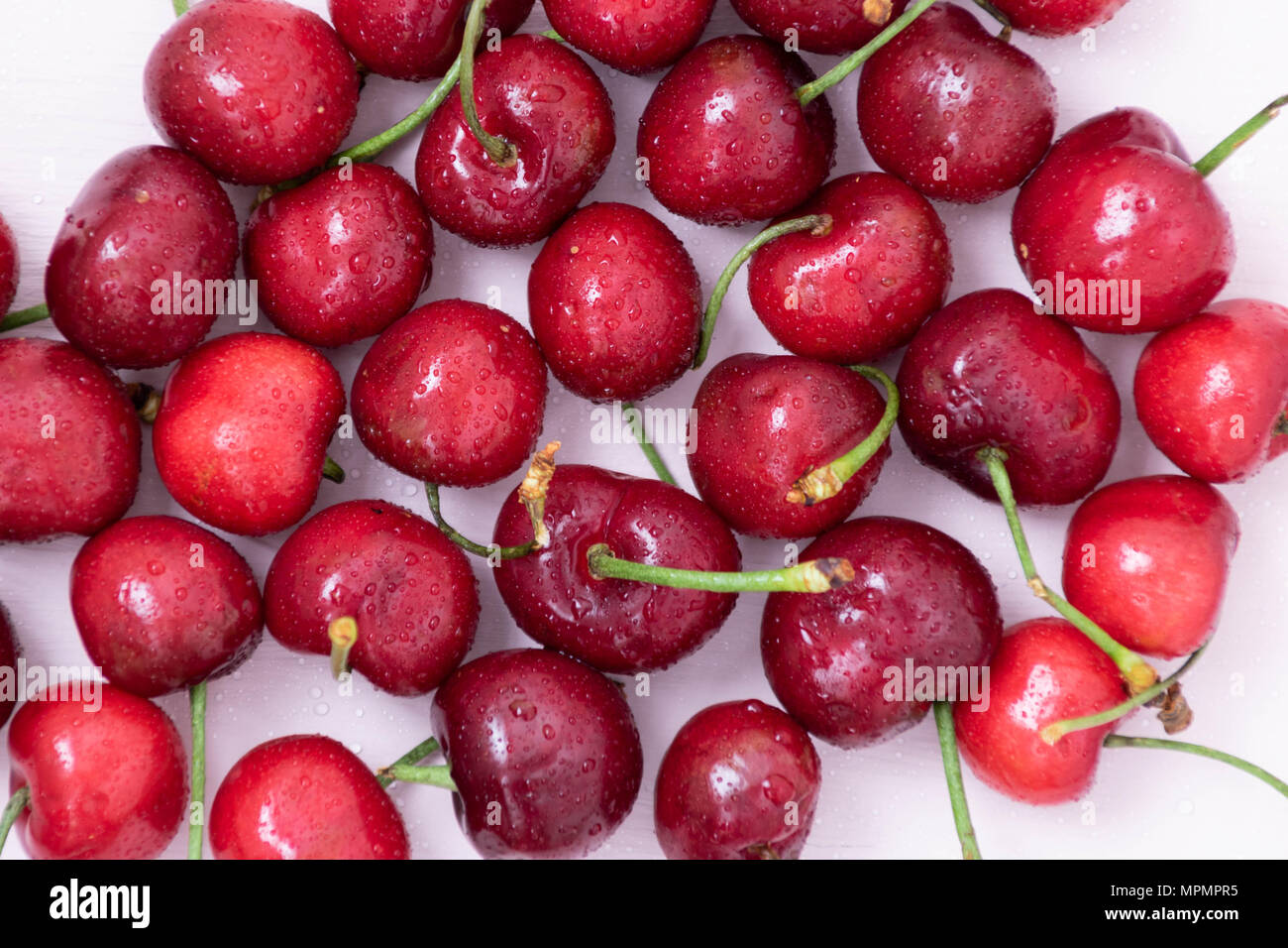 Red ripe cherries against light background, daylight, healthy eating ...