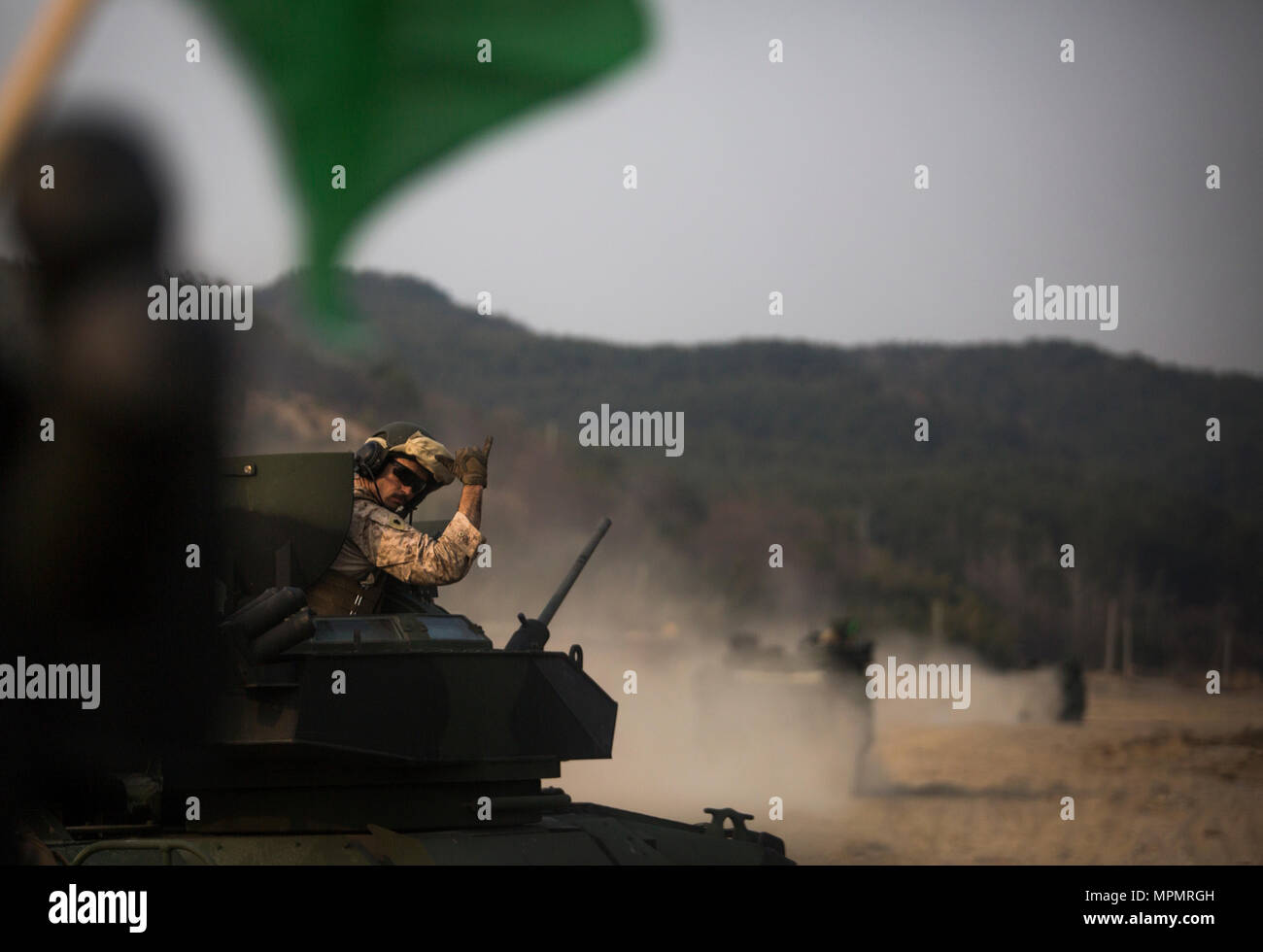 Sgt. Joshua Kelly signals for the next assault amphibious vehicle to follow him after live fire drills, March 28, 2017, at Susong Ri live fire range, Republic of Korea, during Korea Marine Exercise Program 17-6. The KMEP series of exercises continually evolves to maintain the highest level of readiness in defense of ROK through realistic training. Kelly, a Victoria, Texas, native is a crew chief with Company C, 4th Assault Amphibian Battalion. The company, a reserve unit based out of Galveston, Texas, is currently supporting Combat Assault Battalion, 3rd Marine Division, III Marine Expeditiona Stock Photo