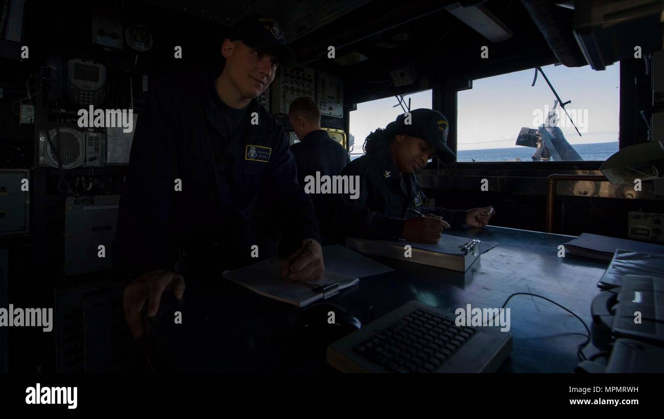 Quartermaster Seaman Douglas Mahan and Quartermaster 2nd Class Brittney Hines record the ship’s position in the deck log aboard USS Leyte Gulf (CG 55) April 4, 2017. Leyte Gulf is conducting naval operations in the U.S. 6th Fleet area of operations in support of U.S. national security interests in Europe. (U.S. Navy photo by Mass Communication Specialist 2nd Class Sonja Wickard/Released) Stock Photo
