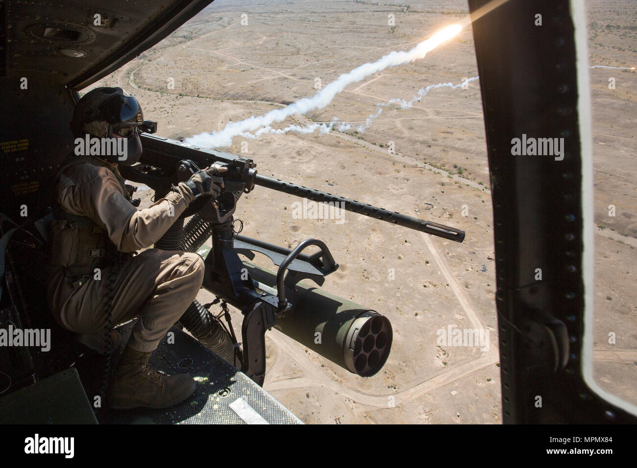 U.S. Marine Corps Cpl. Justin Gilstrap, a crew chief with Marine Light Attack Helicopter Squadron 167 (HMLA-167), fires a GAU-21 .50-caliber machine gun during aerial gunnery refinement drills at Chocolate Mountain Aerial Gunnery Range, California, April 5, 2017. Weapons and Tactics Instructor 2-17 is a seven-week training event hosted by Marine Aviation Weapons and Tactics Squadron One (MAWTS-1) cadre. (U.S. Marine Corps photo by Lance Cpl. Michaela Gregory) Stock Photo