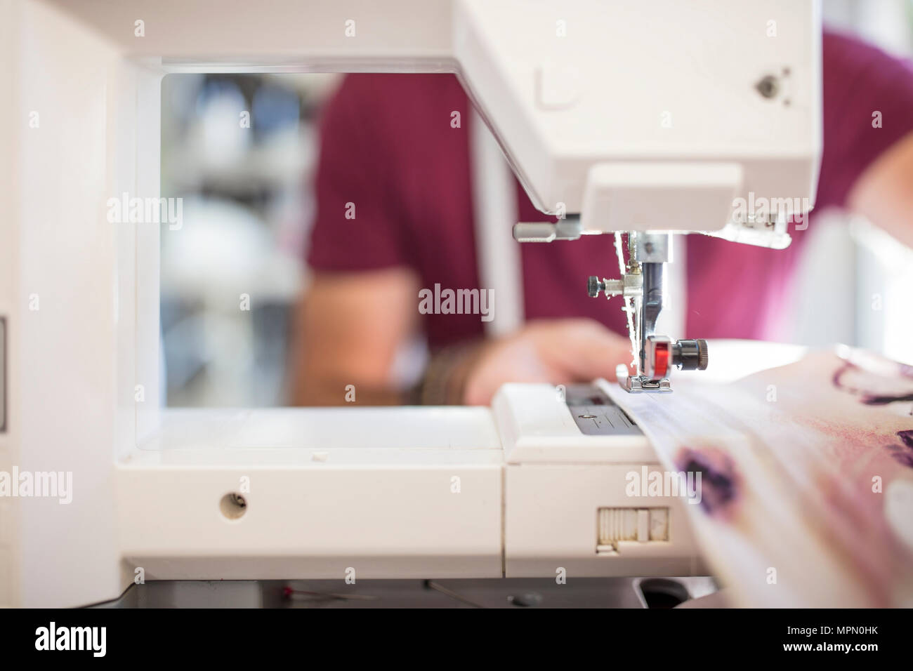 Close-up of man using sewing machine Stock Photo