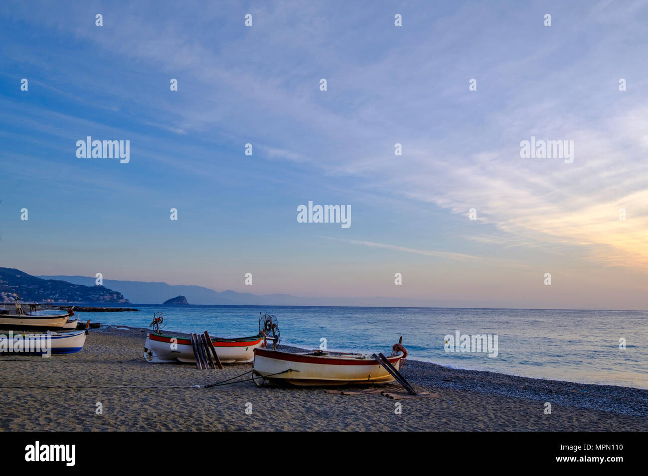 Italy, Liguria, Riviera di Ponente, Noli, fishing boats at beach at sunrise Stock Photo