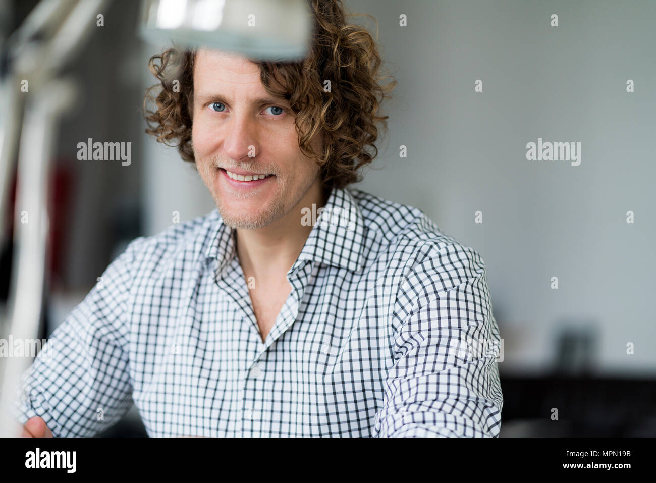 Portrait of a smiling businessman sitting in his office Stock Photo - Alamy
