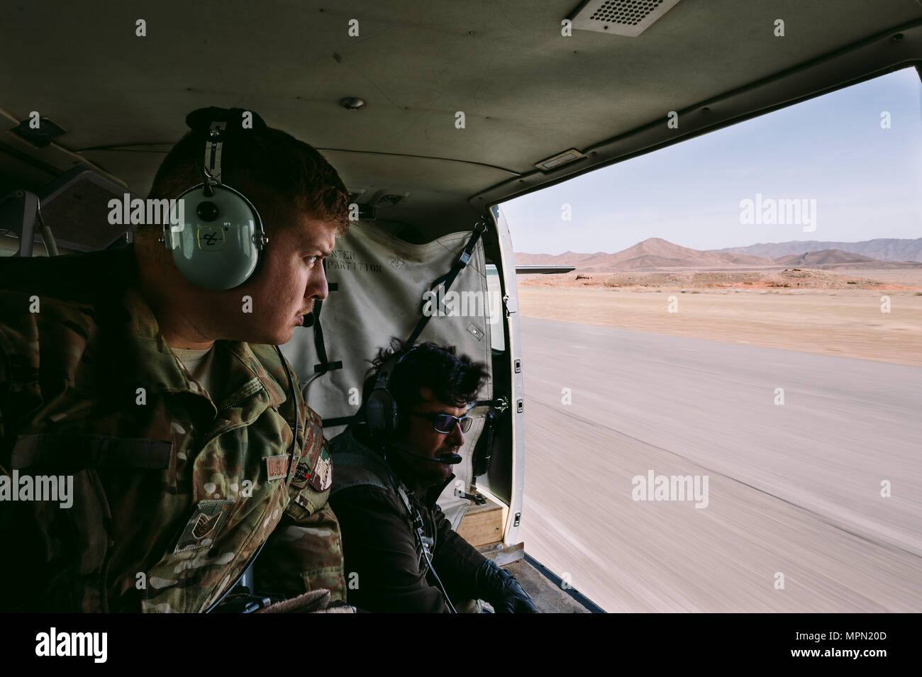 An Airman with Train, Advise, Assist Command-Air, as part of Resolute Support Mission, works in tandem with an Afghan counterpart to practice air drops near Kabul, Afghanistan, March 19, 2017. The TAAC-Air advisors foster working relationships and fortify confidence in the mission. (U.S. Air Force photo by Senior Airman Jordan Castelan) Stock Photo