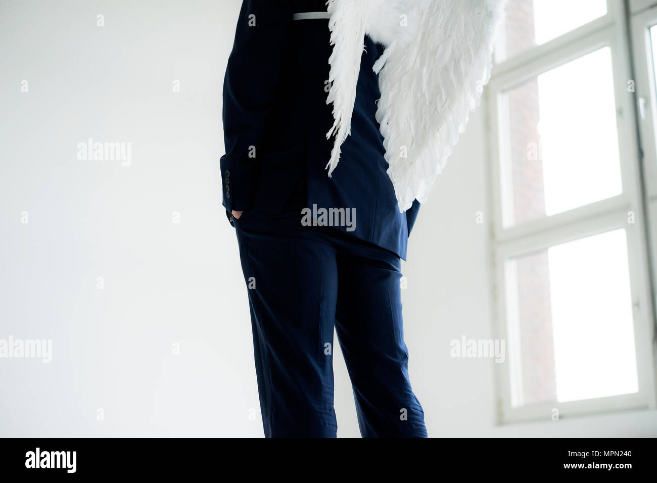 Businessman wearing suit and angel's wings, rear view Stock Photo