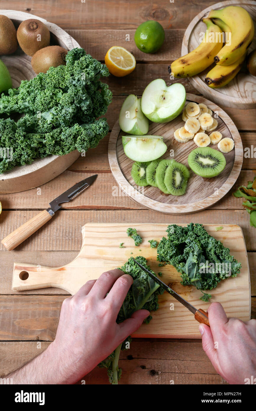 Man preparing green smoothie cutting kale Stock Photo