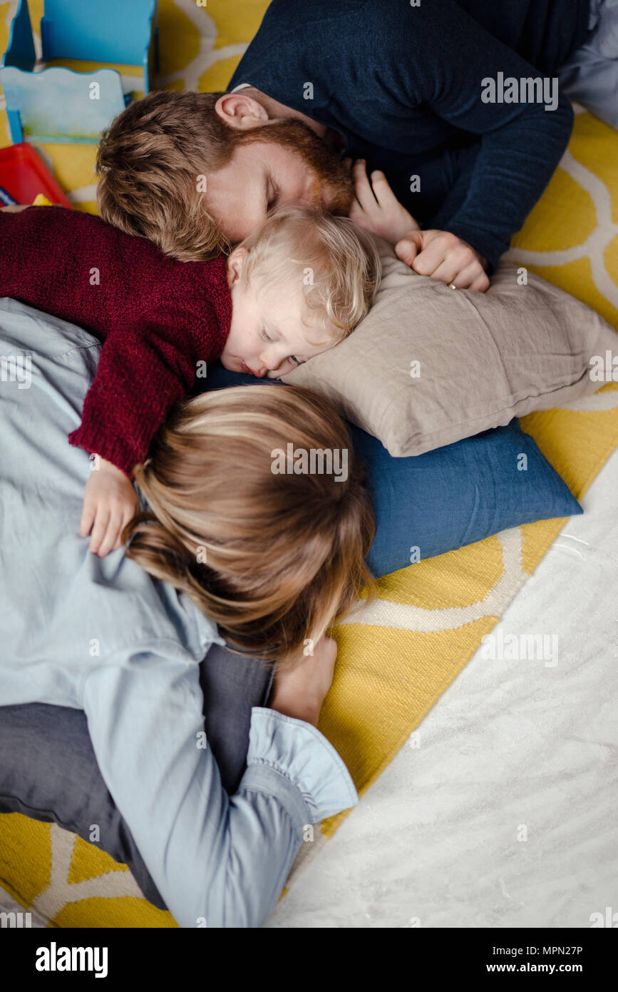 Tiered family resting together on the floor after playing Stock Photo