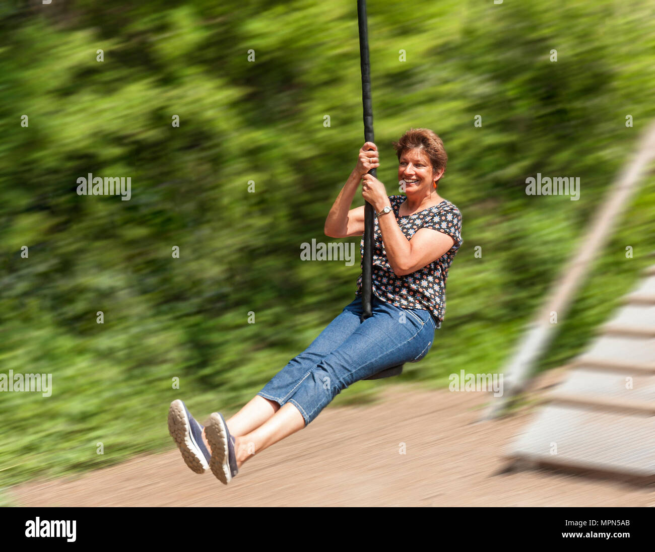 Middle age woman on a zip wire. Stock Photo