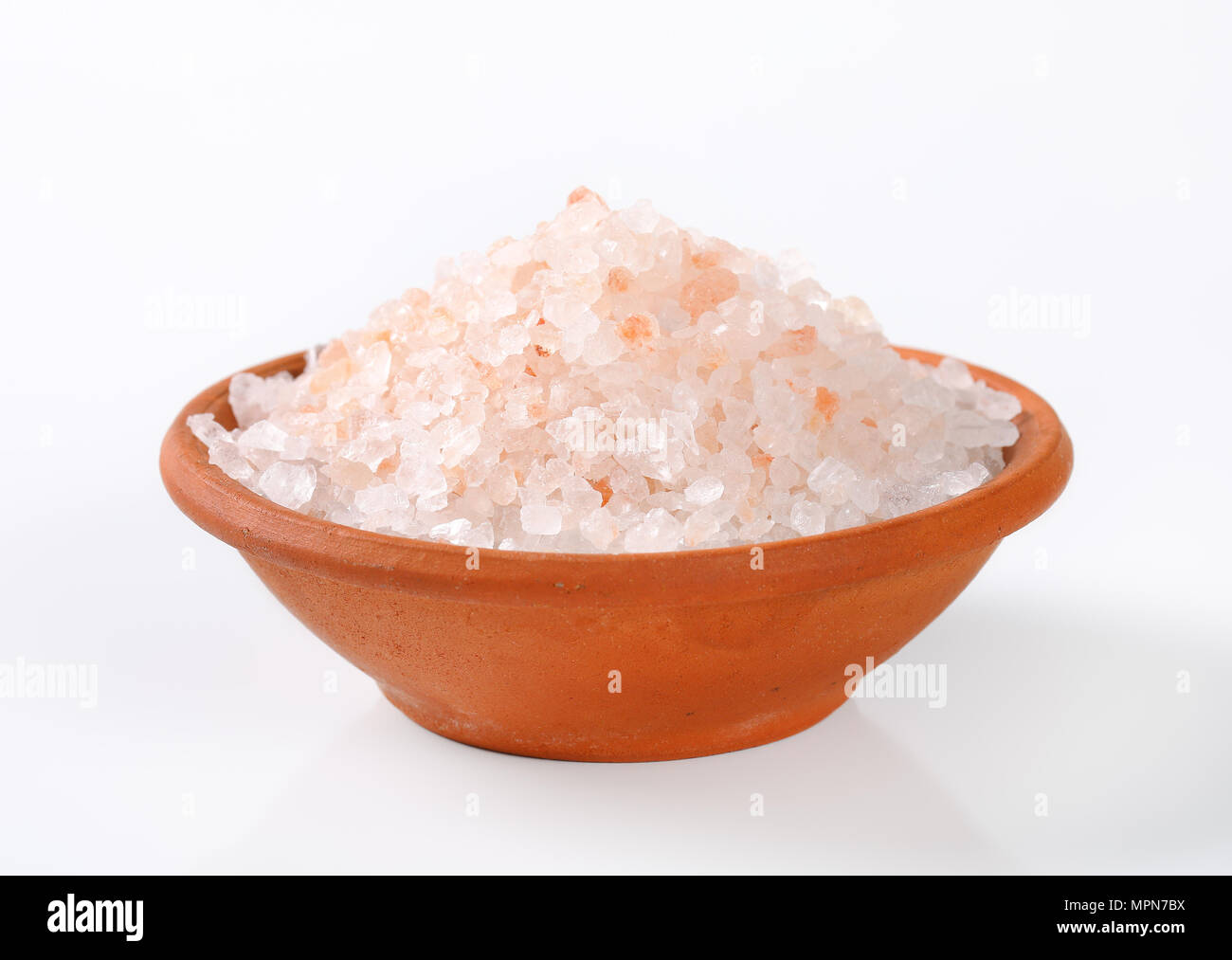 bowl of coarse grained salt on white background Stock Photo