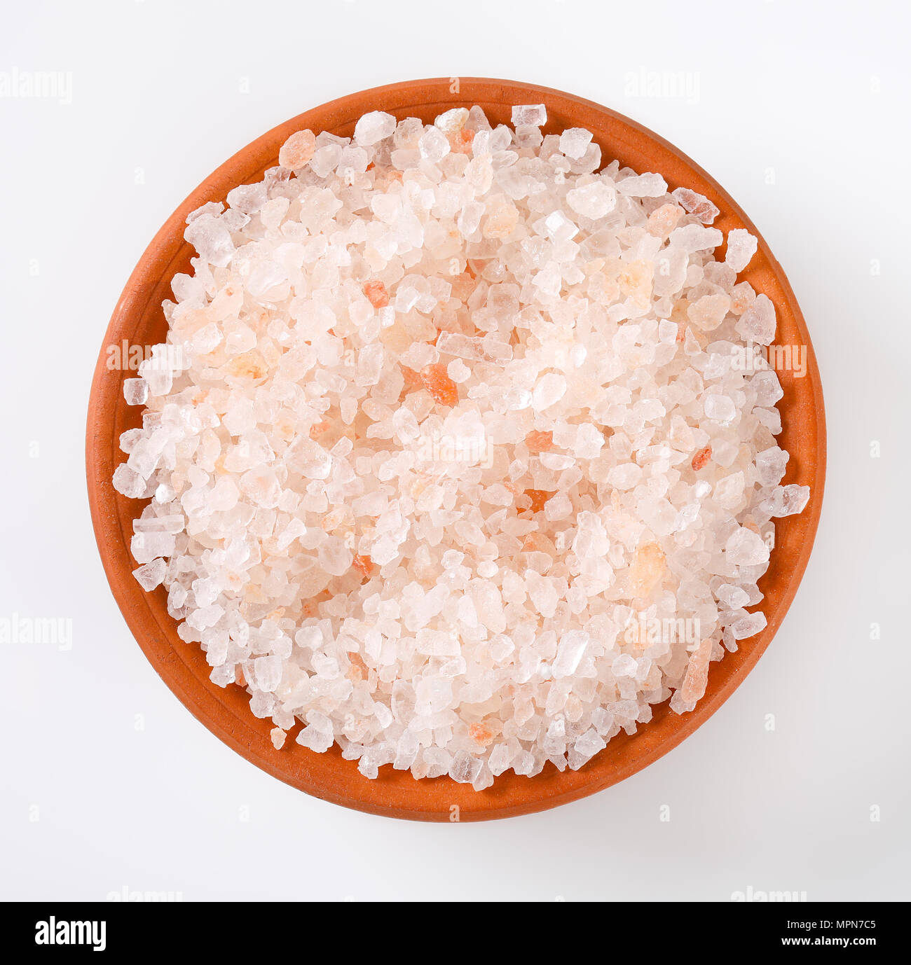 bowl of coarse grained salt on white background Stock Photo