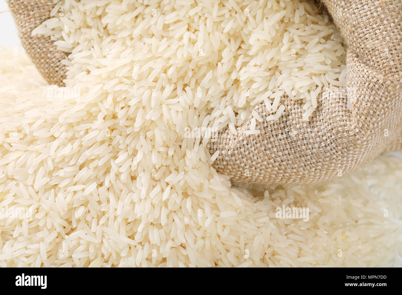 bag and pile of white long grained rice - detail Stock Photo