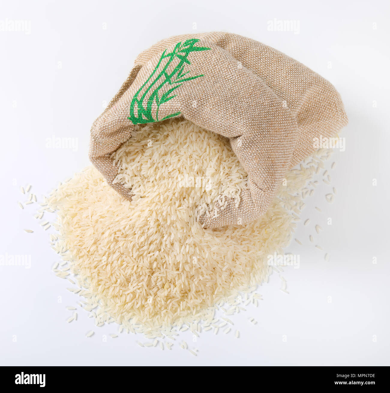 bag and pile of white long grained rice on white background Stock Photo