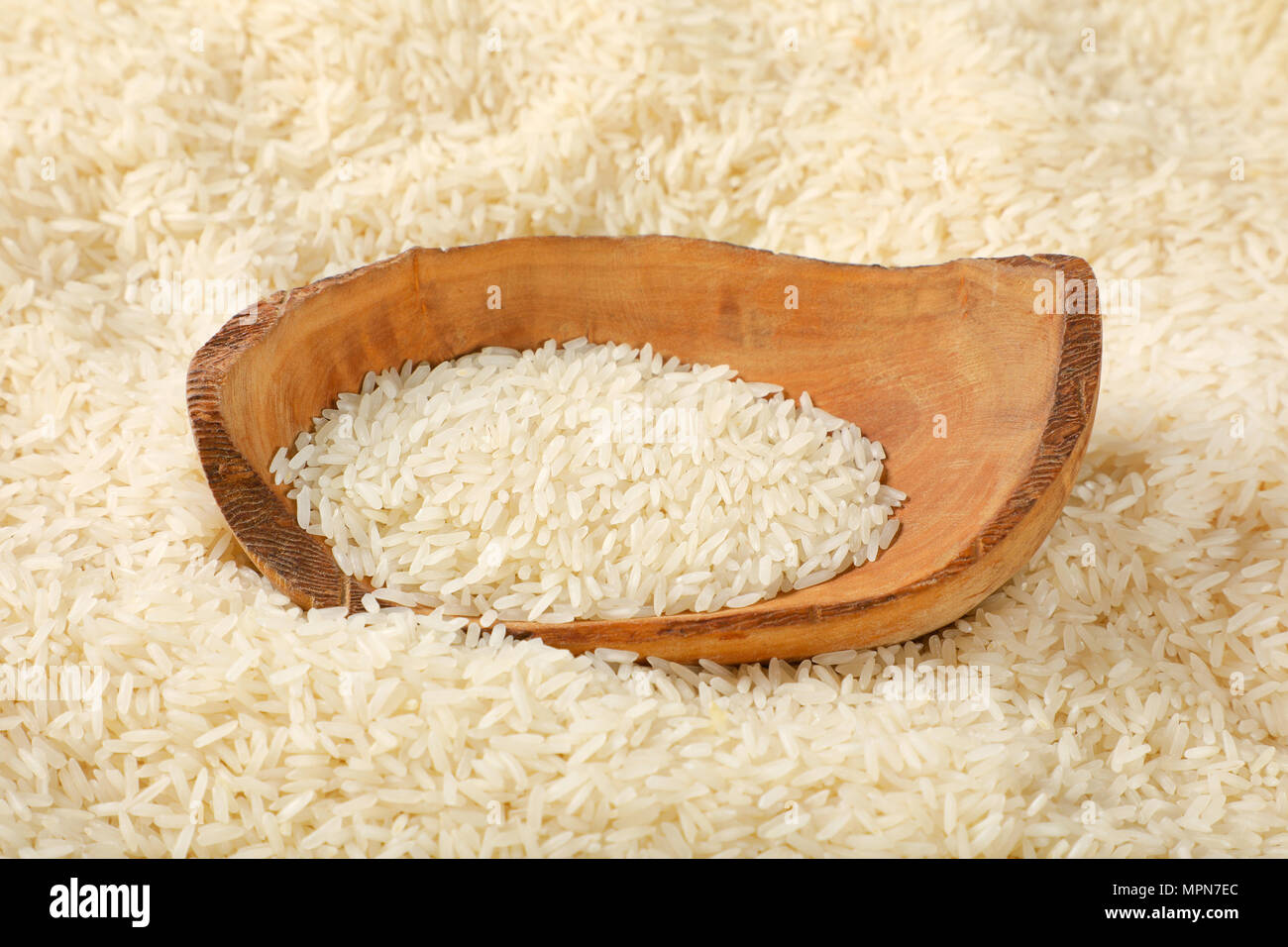 bowl of white long grained rice on rice background Stock Photo
