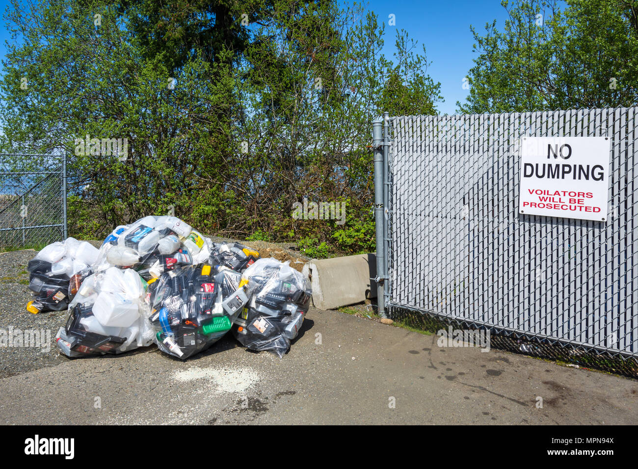 Rubbish dumped next to no dumping sign - Buckley Bay, British Columbia, Canada. Stock Photo