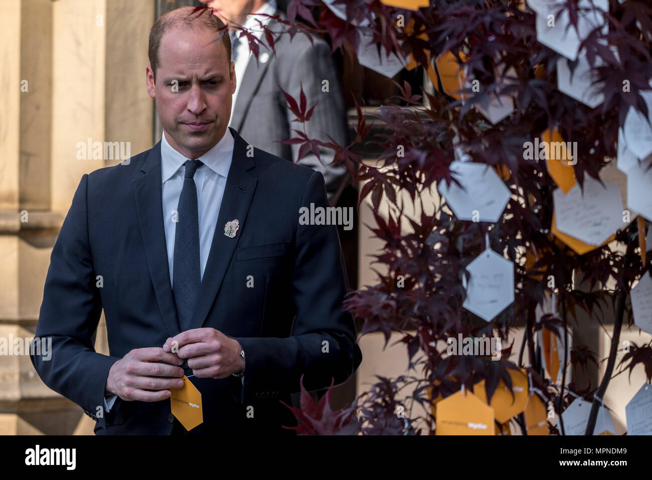 Prince William hangs a personalised hand-written message on one of 22 'Trees of Hope' as he leaves Manchester Cathedral after the national service of commemoration remembering the victims of the Arena bomb attack in Manchester, Britain, on May 22, 2018. Prince William and British Prime Minister Theresa May joined other politicians, as well as family members of those killed, and first responders to the scene of the terror attack, whilst thousands of people gathered in Manchester Tuesday on the first anniversary of a terror attack in the city which left 22 people dead. Stock Photo