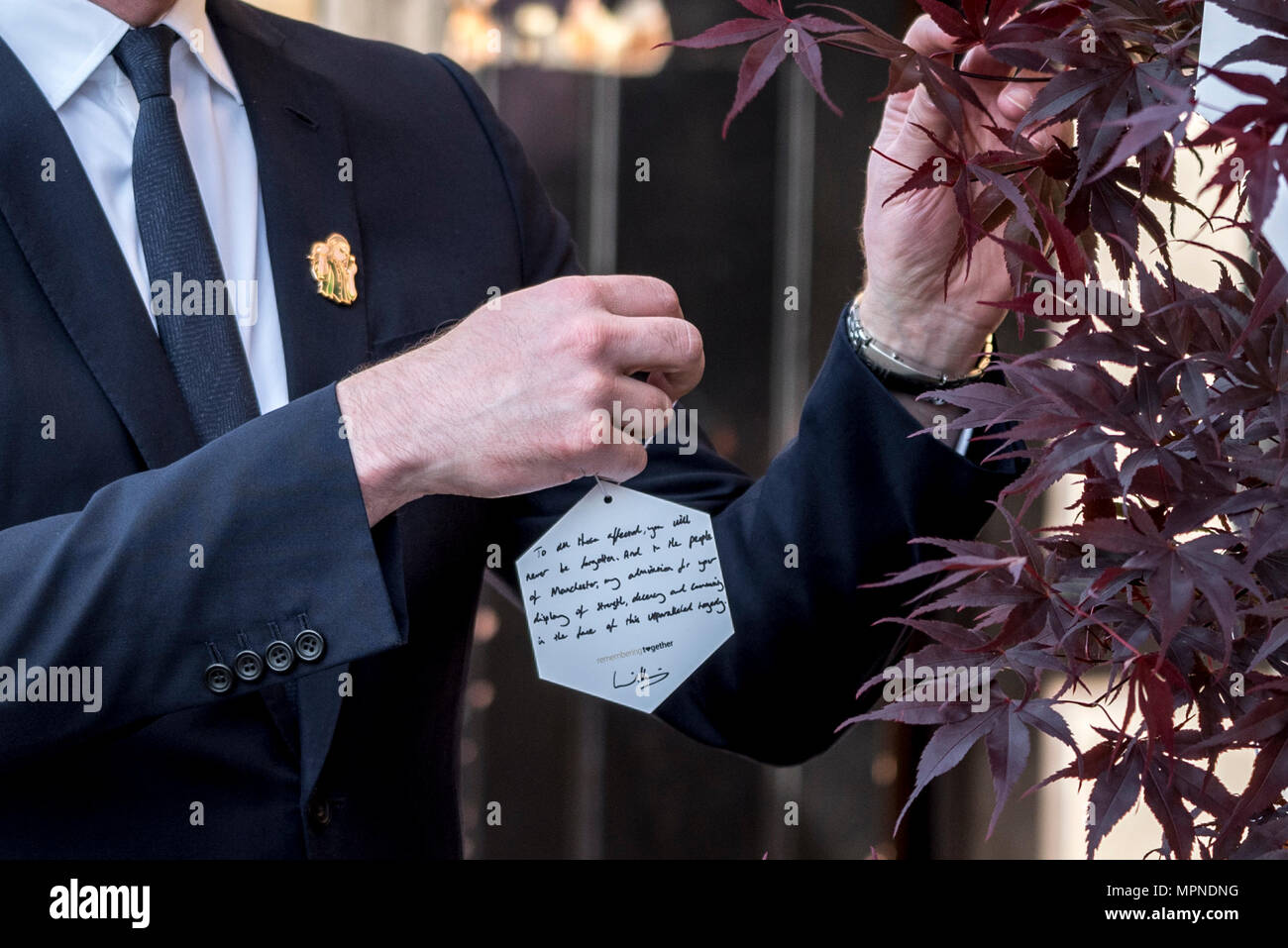 Prince William hangs a personalised hand-written message on one of 22 'Trees of Hope' as he leaves Manchester Cathedral after the national service of commemoration remembering the victims of the Arena bomb attack in Manchester, Britain, on May 22, 2018. Prince William and British Prime Minister Theresa May joined other politicians, as well as family members of those killed, and first responders to the scene of the terror attack, whilst thousands of people gathered in Manchester Tuesday on the first anniversary of a terror attack in the city which left 22 people dead. Stock Photo