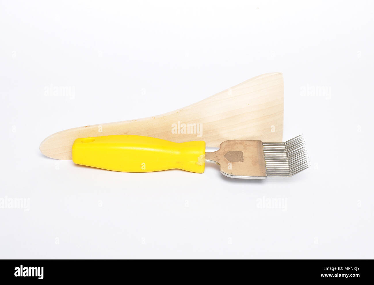 Uncapping fork and honey scraper on white Stock Photo