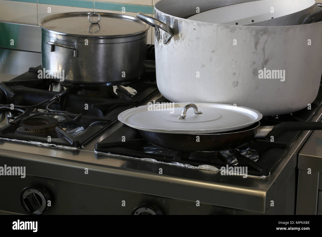 https://c8.alamy.com/comp/MPNX8E/large-industrial-cooker-of-a-kitchen-of-a-restaurant-with-gigantic-pots-and-lids-MPNX8E.jpg