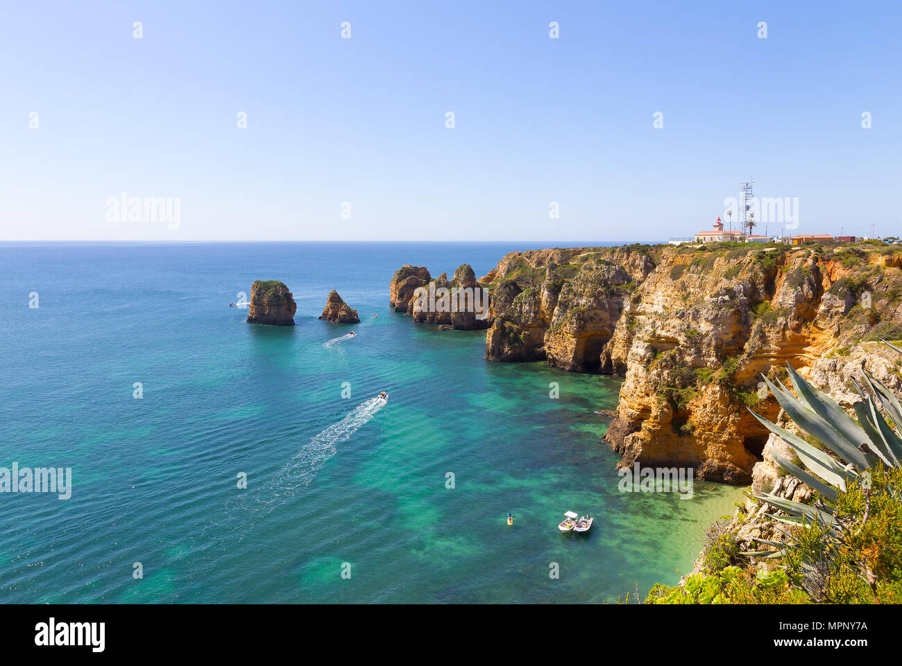 Panoramic overlook of Ponta de Piedade at Lagos, Portugal. Watersport activities in sea waters near the cliffs and caves. Stock Photo
