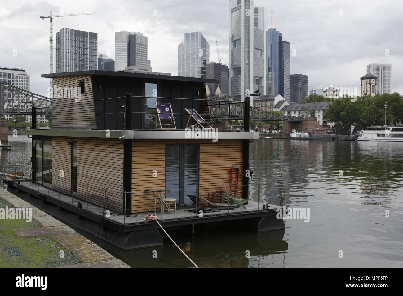 Frankfurt, Germany. 24th May 2018. The houseboat of Leo Oswald is moored at the quays at the river Rain, opposite downtown Frankfurt, with the Frankfurt Skyline in the background. 4 new episodes of the relaunch of the long running TV series 'Ein Fall fuer zwei’ (A case for two) are being filmed in Frankfurt for the German state TV broadcaster ZDF (Zweites Deutsches Fernsehen). It stars Antoine Monot, Jr. as defence attorney Benjamin ‘Benni’ Hornberg and Wanja Mues as private investigator Leo Oswald. The episodes are directed by Thomas Nennstiel. The episodes are set to air in October. Stock Photo