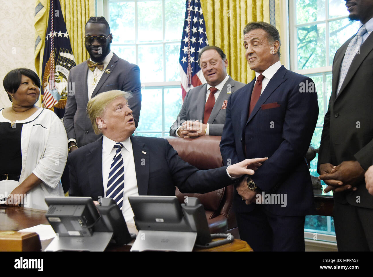 Washington, District of Columbia, USA. 24th May, 2018. United States President Donald J. Trump acknowledges actor Sylvester Stallone after signing an Executive Grant of Clemency for former heavyweight champion Jack Johnson in the Oval Office of the White House on May 24, 2018 in Washington, DC. Credit: Olivier Douliery/Pool via CNP Credit: Olivier Douliery/CNP/ZUMA Wire/Alamy Live News Stock Photo