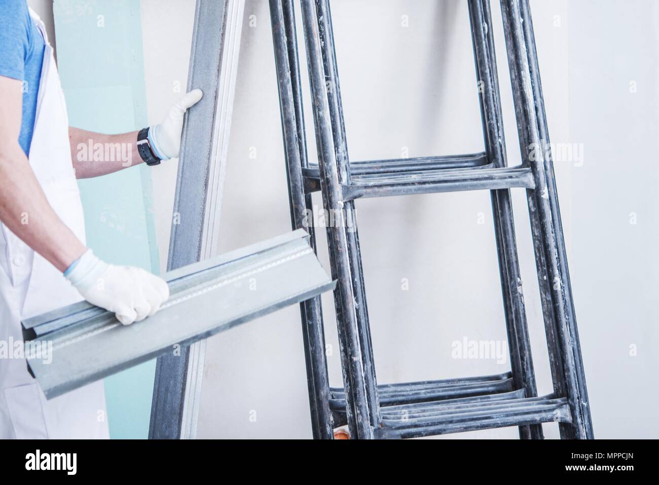 Home Remodeling Theme. Caucasian Construction Worker and the Scaffolding Stock Photo