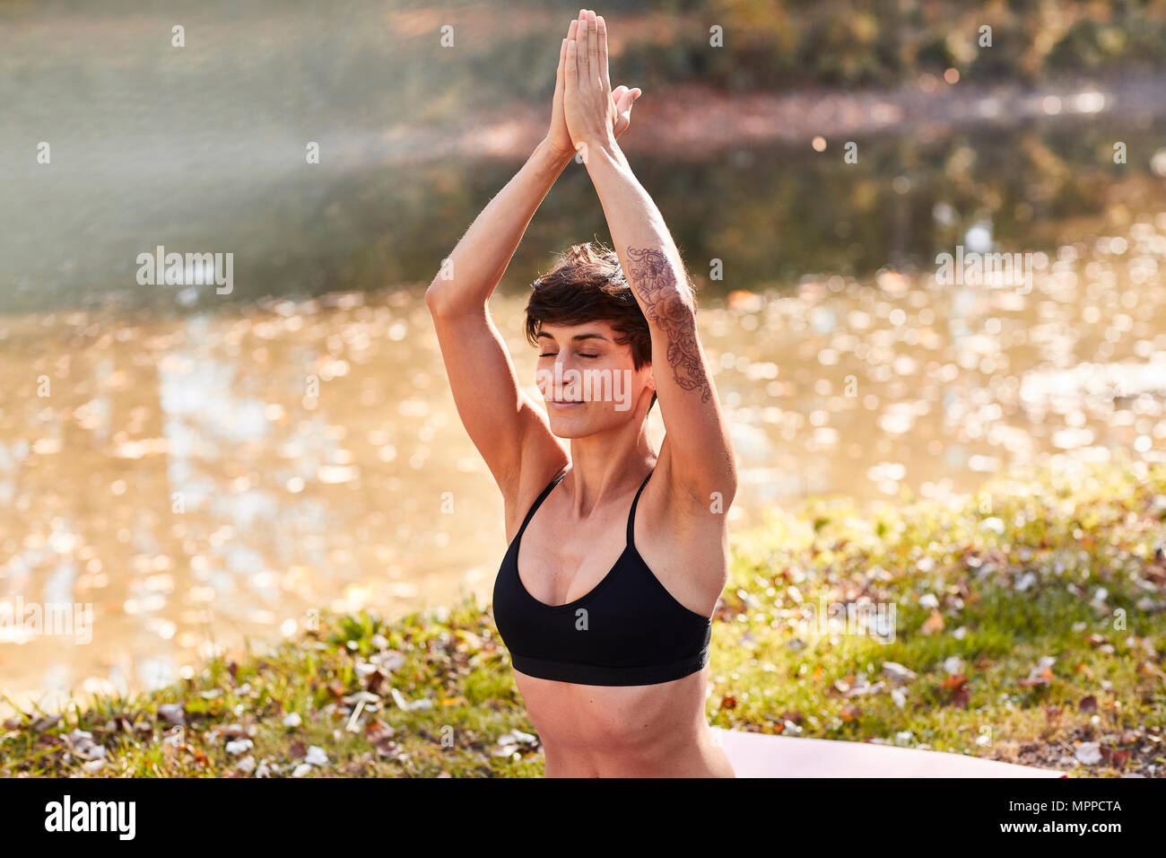 Mid adult woman in forest practicing yoga, meditation Stock Photo