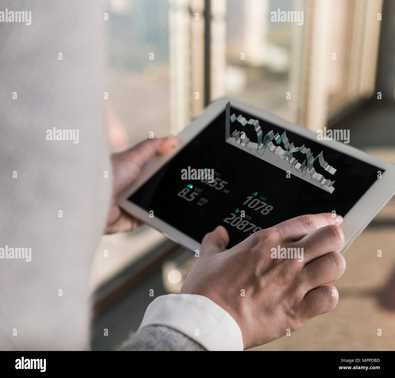 Woman using tablet with data emerging from screen Stock Photo