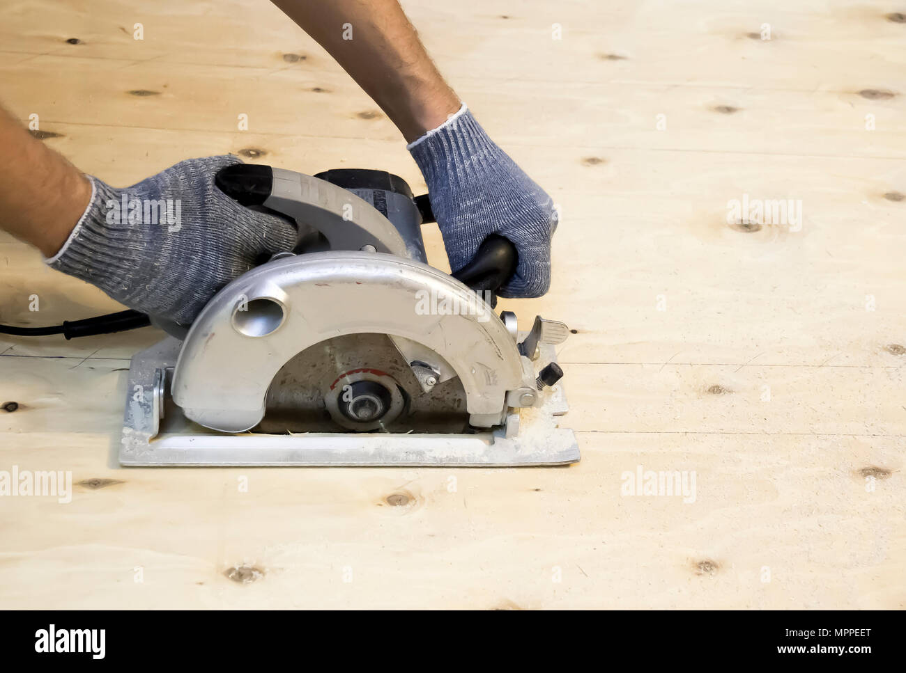 Male hand in working gloves sawn plywood circular saw Stock Photo Alamy
