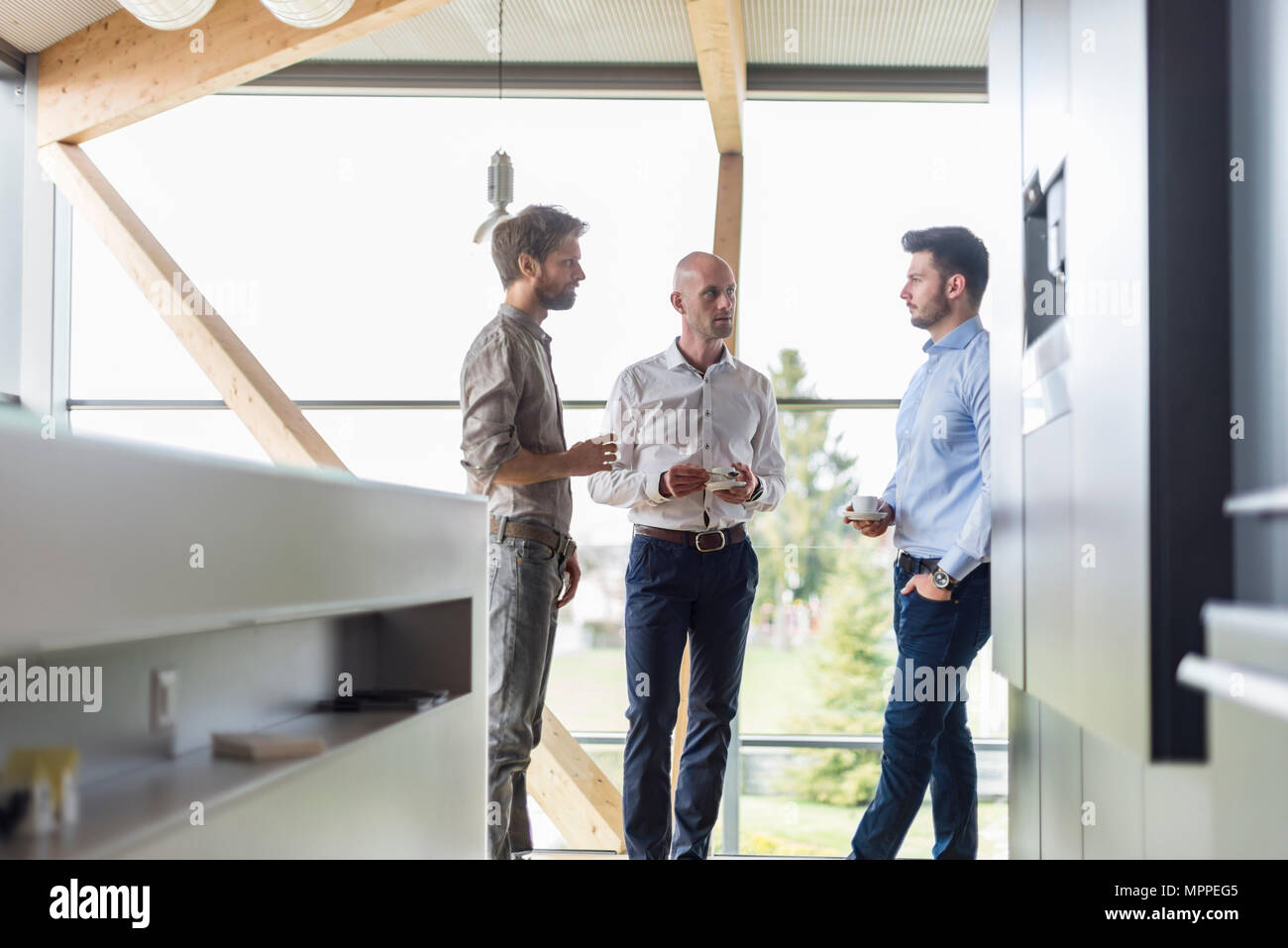 Three businessmen talking during coffee break Stock Photo