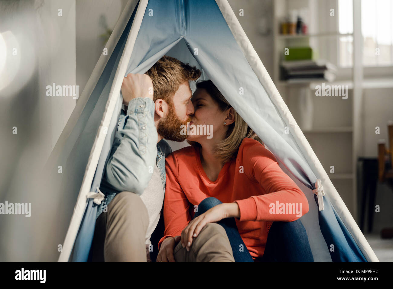 Happy couple at home camping ina tent in the livingroom Stock Photo