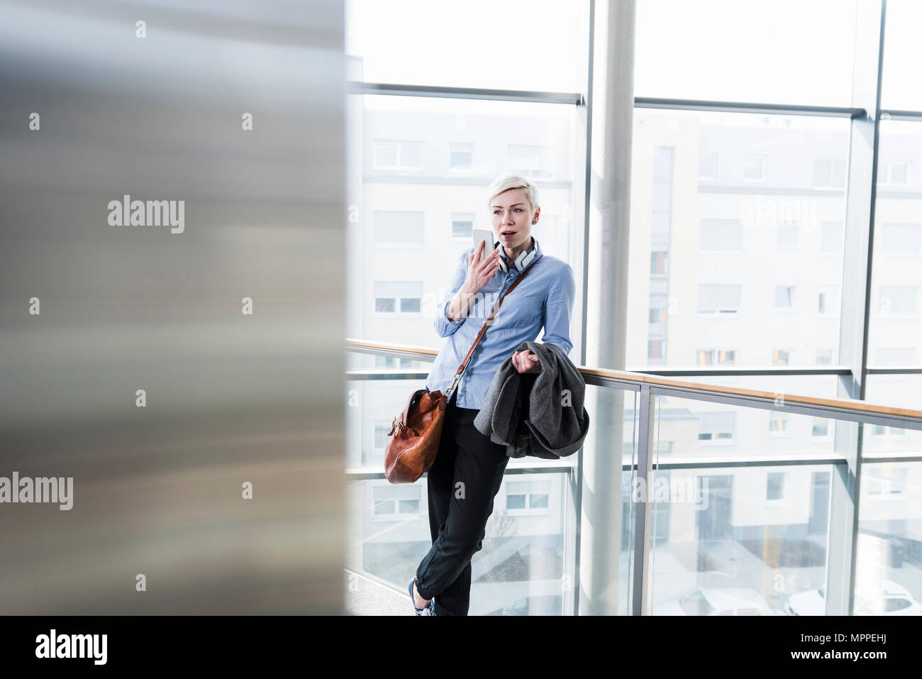 Woman in office building using cell phone Stock Photo